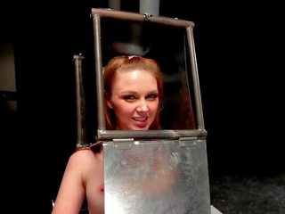 BDSM babe with head in steel box spaked