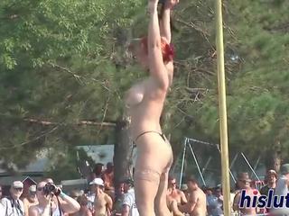 Valdzinošs rūdmataina performs striptīzs uz publisks